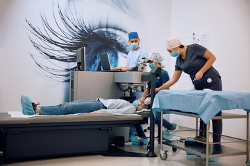 Team of ophthalmologists performing laser eye surgery at the clinic.