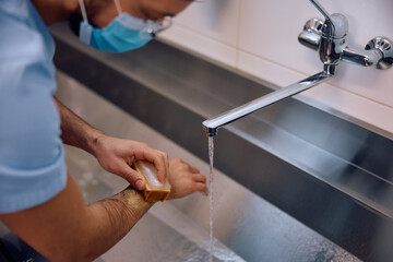 Male doctor washing hands before the surgery in hospital.