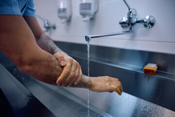 Close up of doctor washing hands while preparing for a surgery at the clinic.