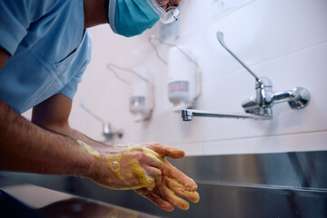 Close up of surgeon washing hands while preparing for operating room.