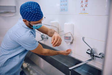 Male doctor washing his hand before getting into operating room inroom hospital.