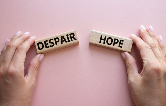 Despair or Hope symbol. Concept word Despair or Hope on wooden blocks. Businessman hand. Beautiful pink background. Business and Despair or Hope concept. Copy space