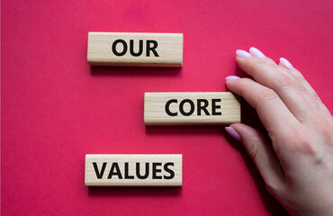 Our core values symbol. Concept words Our core values on wooden blocks. Beautiful red background....