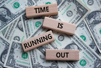 Time is running out symbol. Concept words Time is running out on wooden blocks. Beautiful dollar...