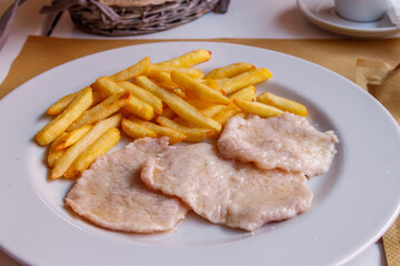 Tasty fried scallops with french fries on a plate