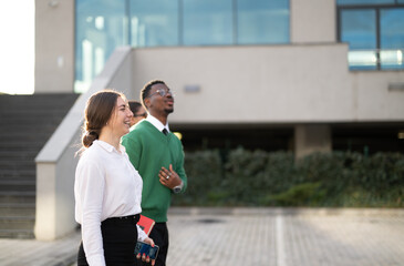 Two professionals in a candid moment outside a modern office, implying a business discussion or partnership.