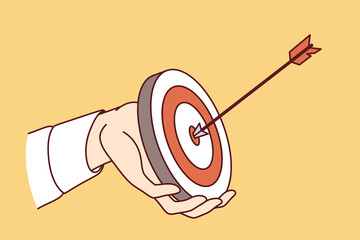 Hand of purposeful business man holding dartboard with arrow hitting target, for concept of career success. Metaphor - purposeful office employee achieved goal by completing job efficiently.