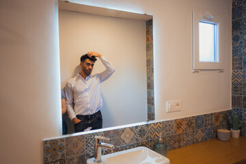 Man standing in front of bathroom mirror