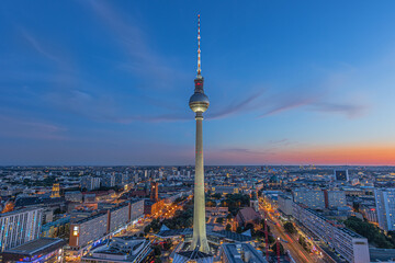 Berlin skyline in the evening at blue hour. Television tower at Alexanderplatz in the center of the capital of Germany. Illuminated buildings and streets with the Red Town Hall