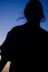 silhouette of a woman with a blue hour sunset background