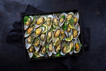 Traditional New Zealand green scallops halved and gratinated with herbs, spices and garlic served...