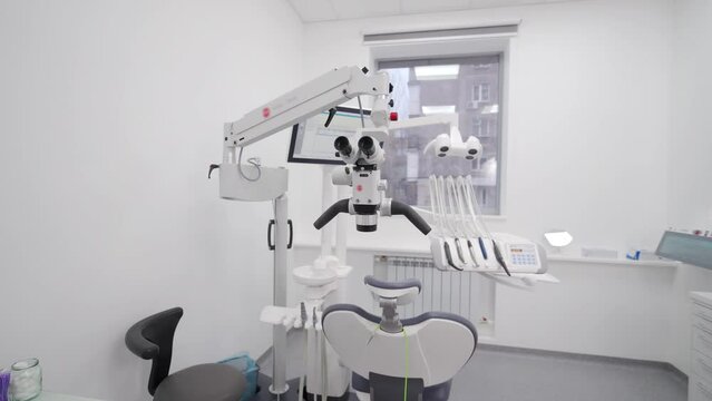 Professional equipment in modern dentistry clinic. Dental microscope with rotary binocular in the stomatology office. Using dental microscope for treating teeth. Microsurgery and prosthetics of teeth.