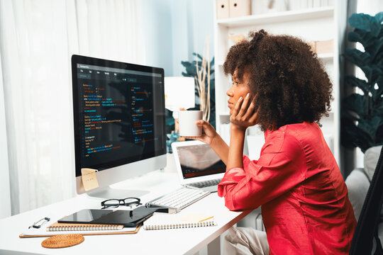 Young working African woman creating coding website developer, thinking data information designer at home office, focusing on laptop Concept of analytical data center in java project job. Tastemaker.