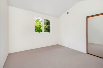 Obraz premium a small empty bedroom with the window open and the floor