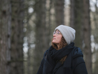 Young Woman Contemplating Nature in Winter Forest