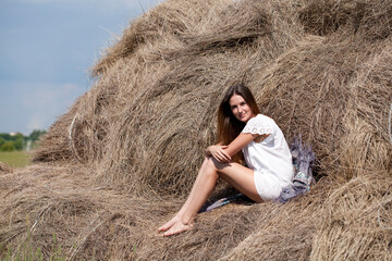 Naklejka na ściany i meble Young beautiful woman in the hayloft in the village
