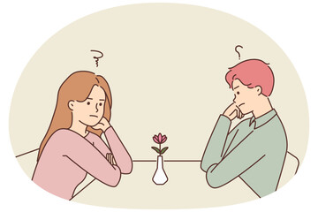 Unhappy man and woman at table in cafe