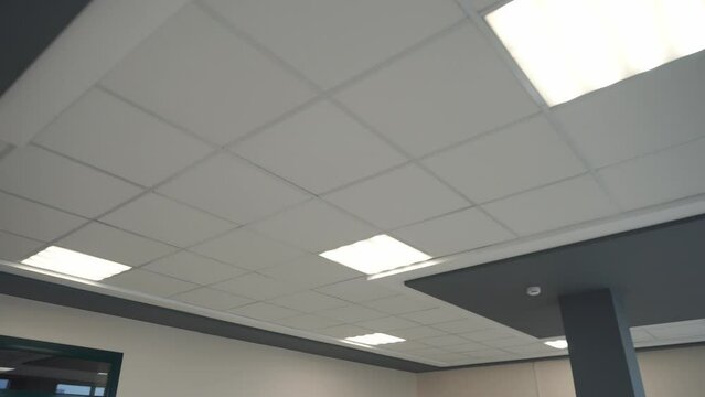 Square lamps on a white office ceiling. Interior design in the office. A fluorescent lamp on a modern suspended ceiling.