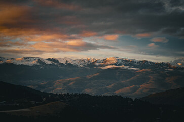 view of the Pyrenees mountains, winter snowy mountain peaks, dark exposure in the setting sun