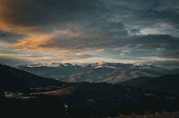 view of the Pyrenees mountains, winter snowy mountain peaks, dark exposure in the setting sun
