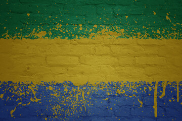 colorful painted big national flag of gabon on a massive brick wall
