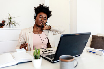 Stressed business woman working from home on laptop looking worried, tired and overwhelmed.