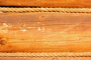 Wooden wall of a cobblestone house, ropes are laid between the logs - close-up, background, wood...