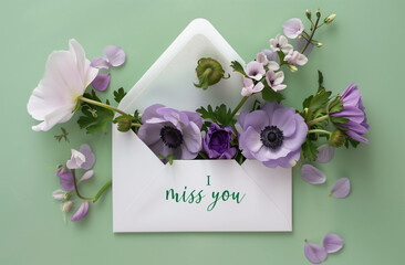 Envelope full of violet anemones with text I MISS YOU