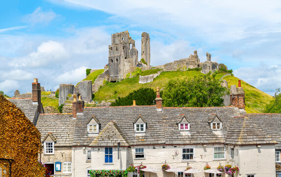 The imposing ruins of the medieval hilltop Corfe Castle, seen above the town of the same name in the village of Corfe Castle, England, United Kingdom.	
