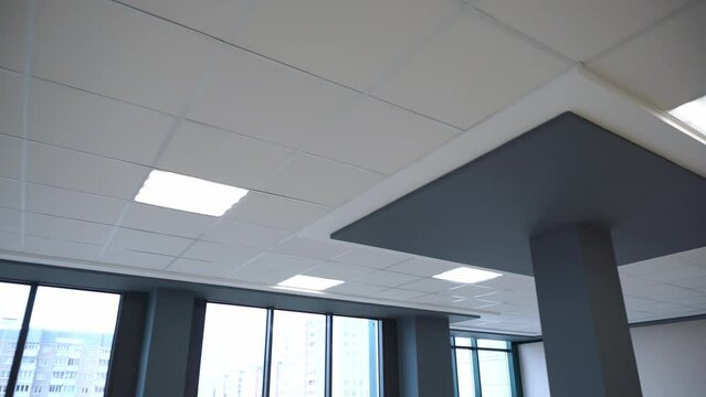 Square lamps on a white office ceiling. Interior design in the office. A fluorescent lamp on a modern suspended ceiling.