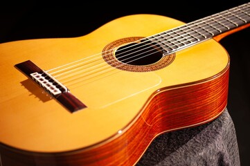 Classical Spanish flamenco guitar close up, dramatically lit isolated on black background with copy...