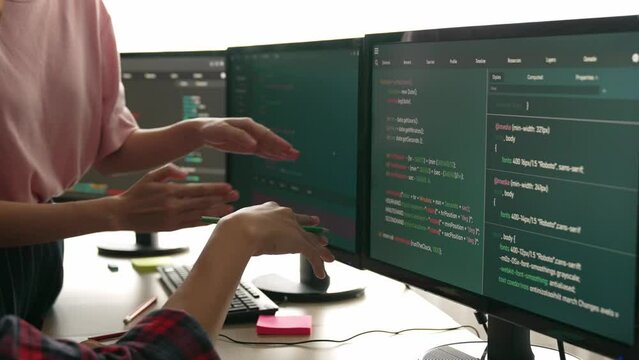 Back end software developer engineer for computer programming working together on debugging writing computing code, solving complex algorithms display on monitor in office. Burgeoning