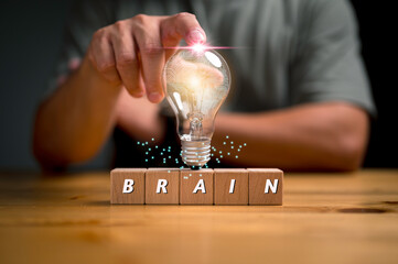 Hand holding light bulbs and brain.Creative thinking ideas for work on desk.education for new...