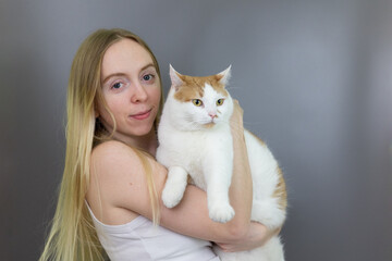 Blonde Girl Holding Pet Cat Close Caring, Pet Owner, Cuddle, Gray Backdrop Isolated Background Posed Portrait