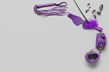 Different purple sex toys on grey background