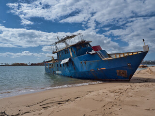 Storm's Aftermath: Iron Boat Stranded on Ferragudo Coastline, Algarve.