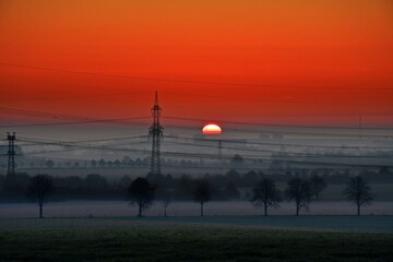 Beautiful sunset with a sky of bright red color and the shadow shade of trees in the valley