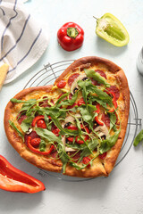 Stand with tasty heart shaped pizza and pepper on light blue background