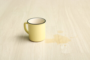 Wooden laminate floor with cup and spilled tea