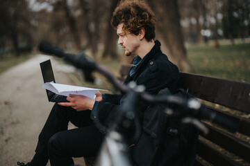 Obraz premium Focused entrepreneur outdoors with laptop and documents, bicycle beside on park bench