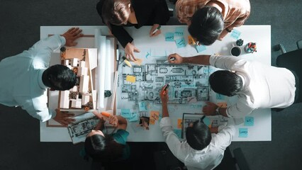 Top aerial view of project manager or civil engineer writing at blueprint and planning building design. Aerial view of architect working together at meeting table with document placed. Alimentation.