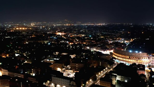Aerial Timelapse: Illuminated Colosseum Amidst Buildings In City At Night - Rome, Italy