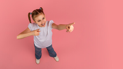 Playful girl pointing at copy space - obrazy, fototapety, plakaty