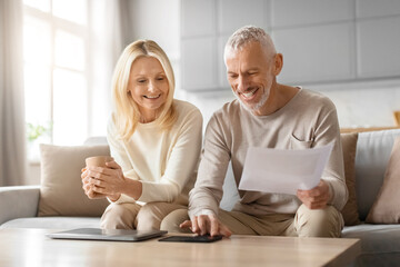 Cheerful couple with financial plans at home