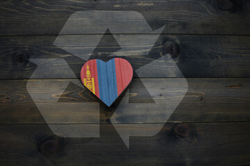 wooden heart with national flag of mongolia near reduce, reuse and recycle sing on the wooden background. concept