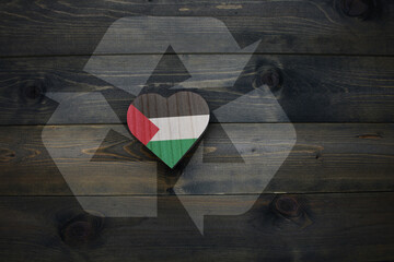 wooden heart with national flag of palestine near reduce, reuse and recycle sing on the wooden...