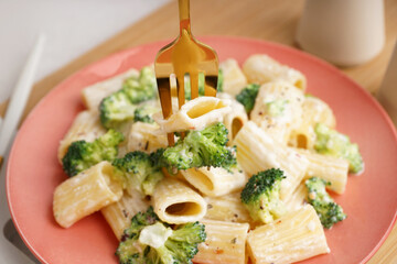 Plate of tasty pasta with broccoli on table