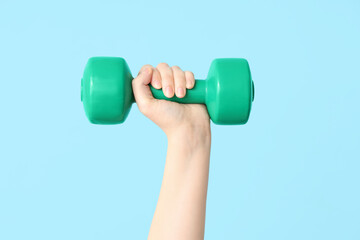 Female hand with dumbbell on color background, closeup - obrazy, fototapety, plakaty