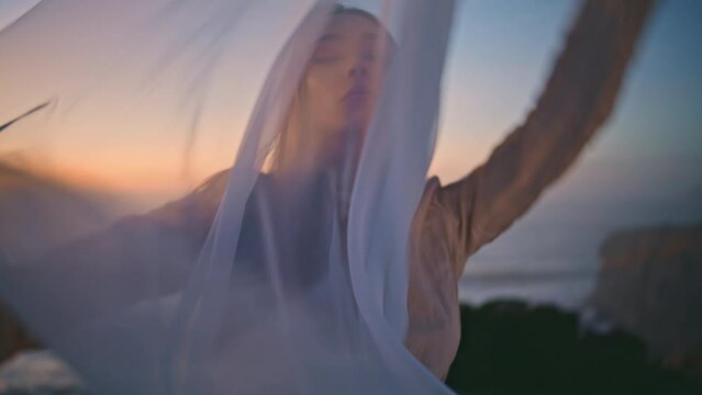 Closeup sensual woman moving hands smoothly with fluttering fabric at sunset