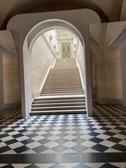 Versailles historical architectural features round archway with black and white tile and stairs...